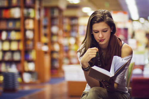 girl reading book in library