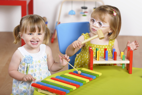 young girls playing with blocks and instruments