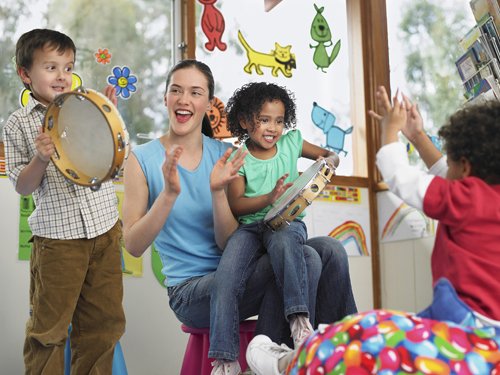 Teacher With Children Playing Music In Class