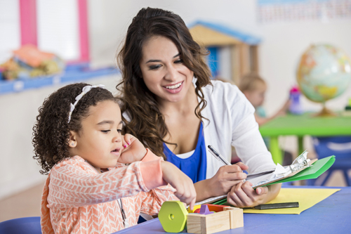 woman helping little girl with blocks