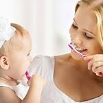 woman and baby brushing teeth Thumbnail