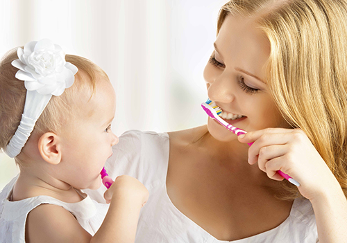woman and baby brushing teeth
