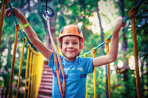 boy walking across bridge in harness
