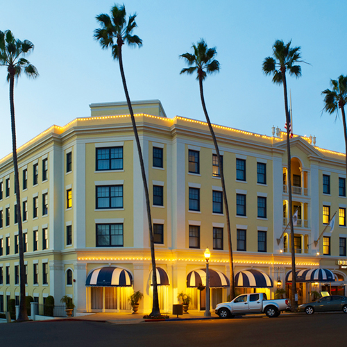 Grande Colonial Hotel with palm trees surrounding it
