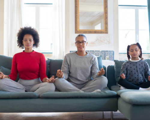 Family meditating on couch.