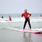 Endless Sun Surf Camp girl surfing at Newport Beach Pier
