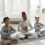 Mother practicing yoga and mindfulness with son and daughter