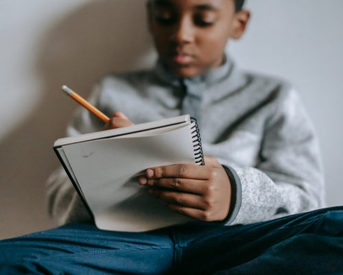 child writing in gratitude journal for mindfulness