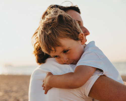 fathfather comforting son with a huger and son hugging