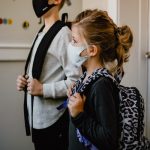girl getting ready to go to school with mask on
