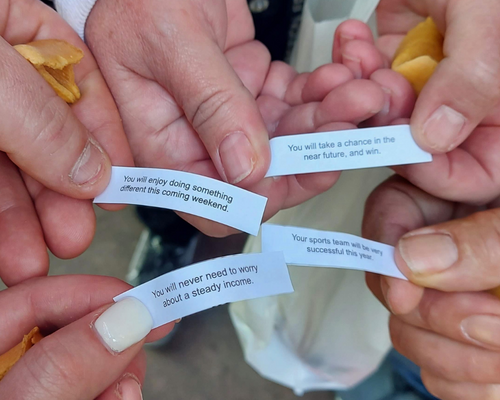 Group of hands holding fortune cookie fortune's china town san francisco