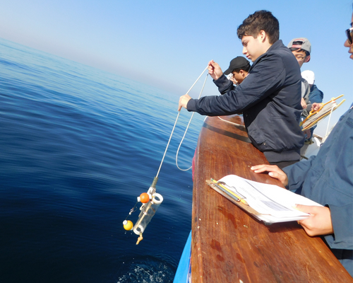 Students deploying water quality sampling bottle