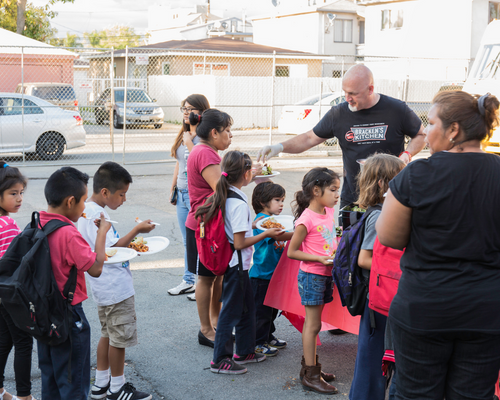 Chef Bill Bracken serving food to children.