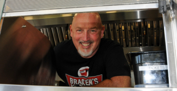 Chef Bill Bracken rising in his food truck window.