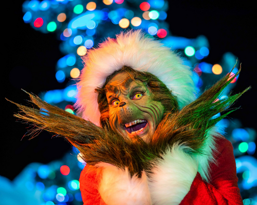 The Grinch posing in front of the Christmas Tree at Universal Studios.