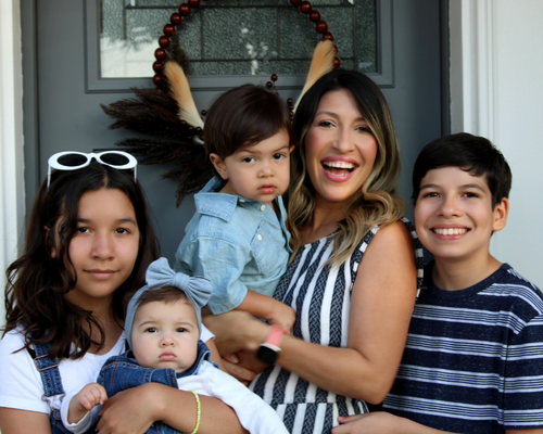 Lillian Lobue with her family in front of a green door 