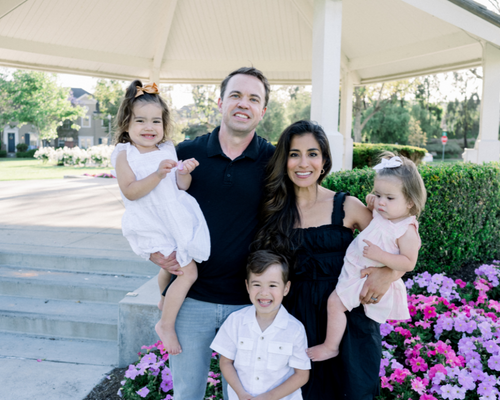 Suzi Crawford with her family in front of pink and purple flowers