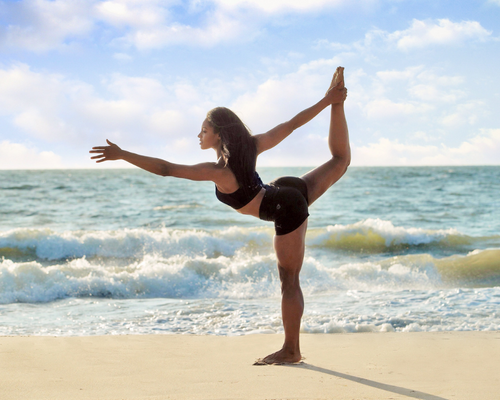 Doctor Desiree Williams doing yoga on the beach.