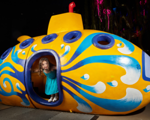 Cute Kid Cover Contest Winner Kendall Ruiz, 3 plays in the submarine that is part of Discovery Cube of Orange County's Ocean Encounter Exhibit