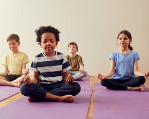 four kids meditating on yoga mats