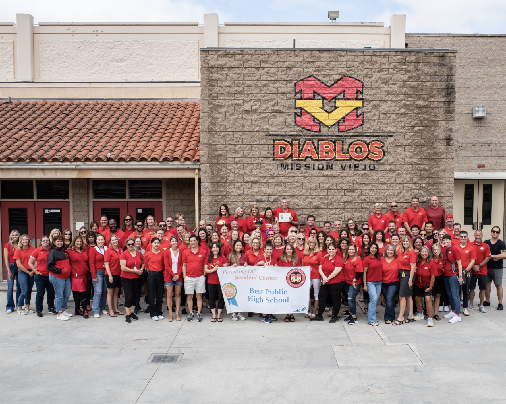 Teachers and staff holding up a readers choice award banner at Mission Viejo High School Best Public High School