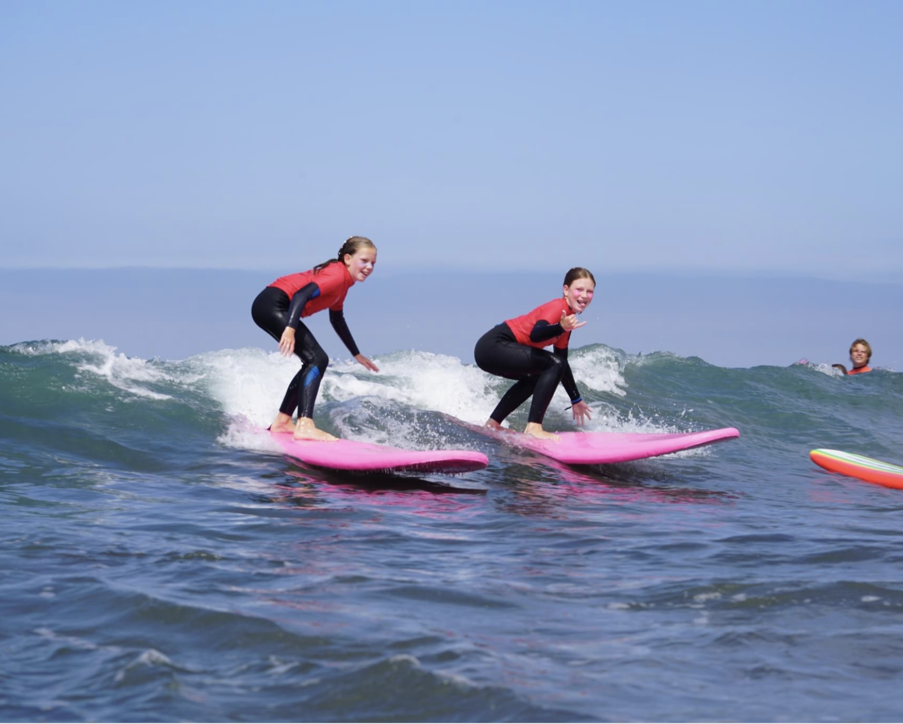 Two girls surfing at Endless Sun Surf Camp Best Surf Camp