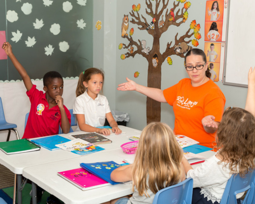 Students raising their hands LangoKids Best Language Program