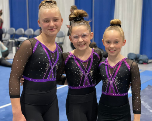Three girls smiling side by side at SCATS Gymnastics Best Competitive Gymnastics Class