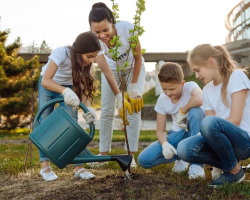Kids helping mother water a tree