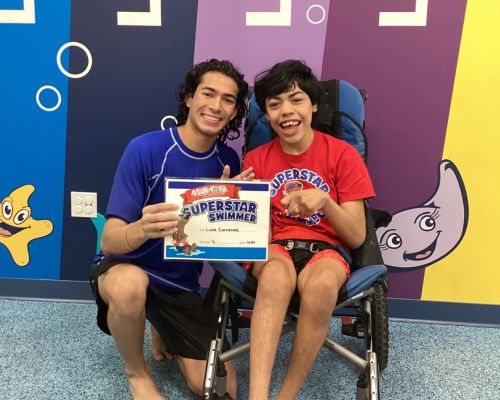 Luke a student at Aqua-Tots with Coach Gerardo Hernandez