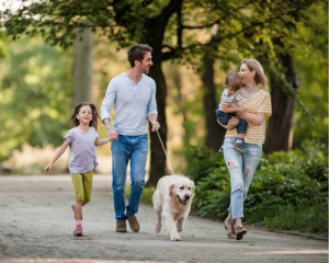 Family walking together on a trail with dog