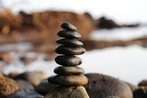 Rocks balanced on top of each other with a lakeside backdrop.
